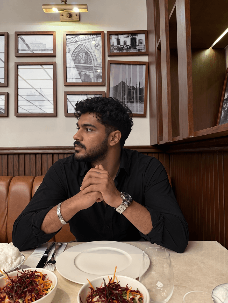 Man in a black shirt sitting at a restaurant table